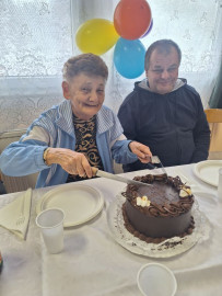 Boldogan vágja fel a tortát 