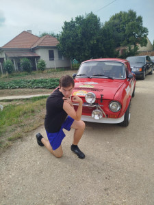 Lakónk pózol a neki tetsző oldtimer sportautó mellett
