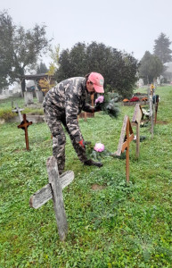 Elhelyezi ellátottunk a csokrot a síron