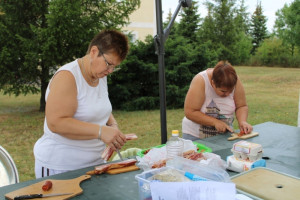 A paprikáskrumpli hozzávalóinak (kolbász, szalonna) szeletelése.