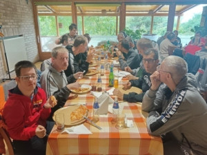 Boldogan ülünk az asztalnál a pizzákkal