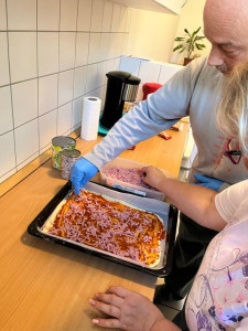 Ellátottaink felügyelet mellet helyezik a kinyújtott tésztát a tepsibe, majd a feltétekkel megszórni azokat.