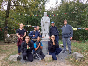 Csoportkép egy buddhista szerzetes szobránál