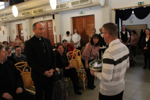 A szentmise után egyik ellátottunk az általuk készített Bódi Mária Magdolna tiszteletére készült utazókavicsokat ad át